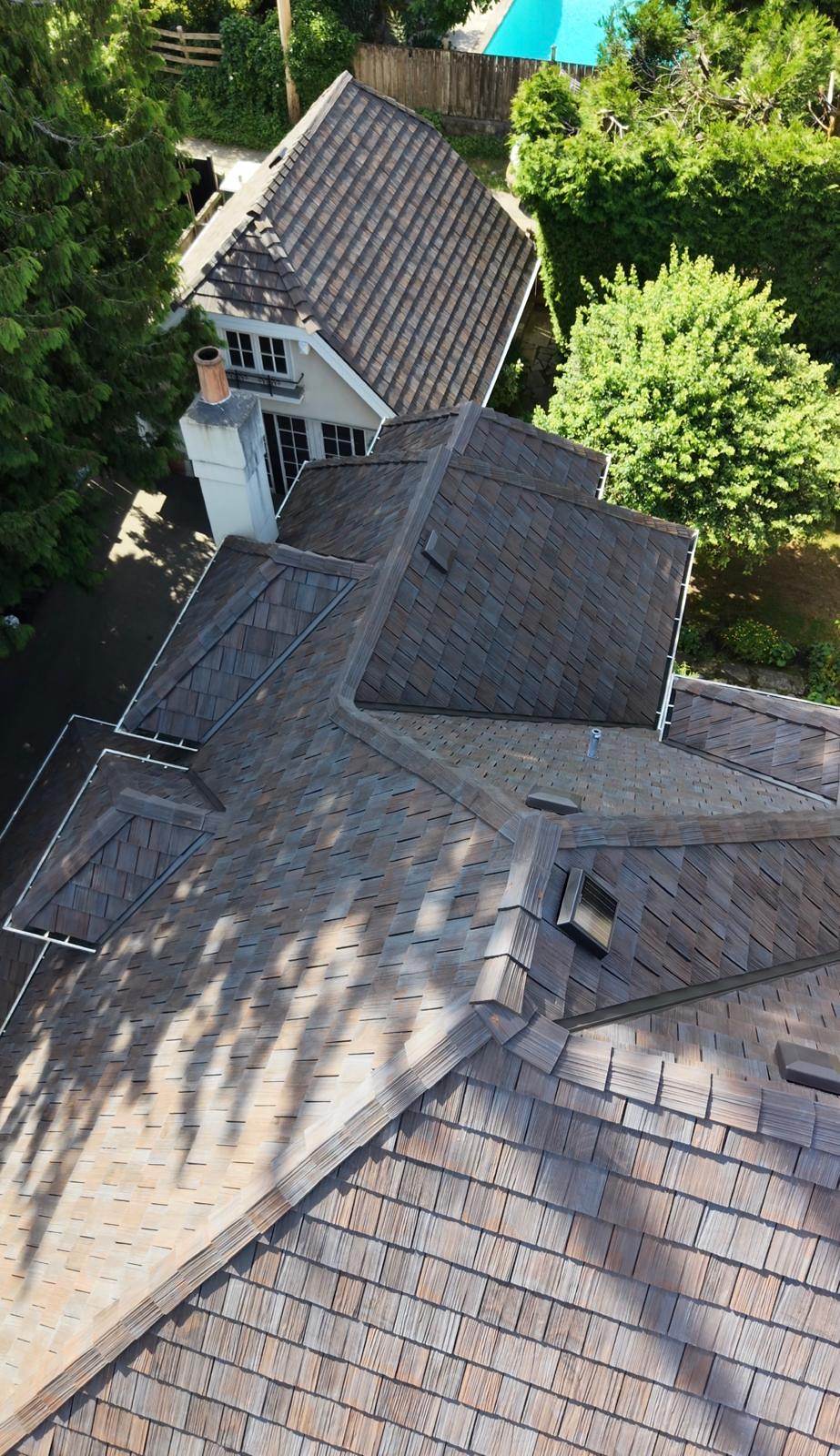 Close view of Brava composite shake courses, hip caps and a valley on a steep roof